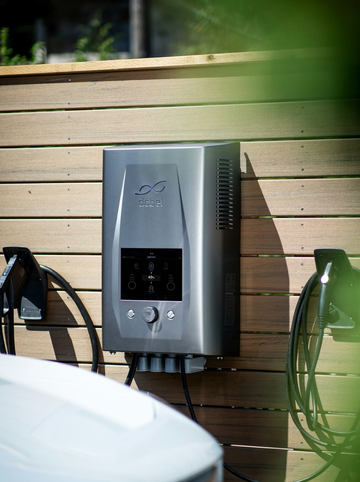 Gray EV charger mounted on a wooden exterior wall